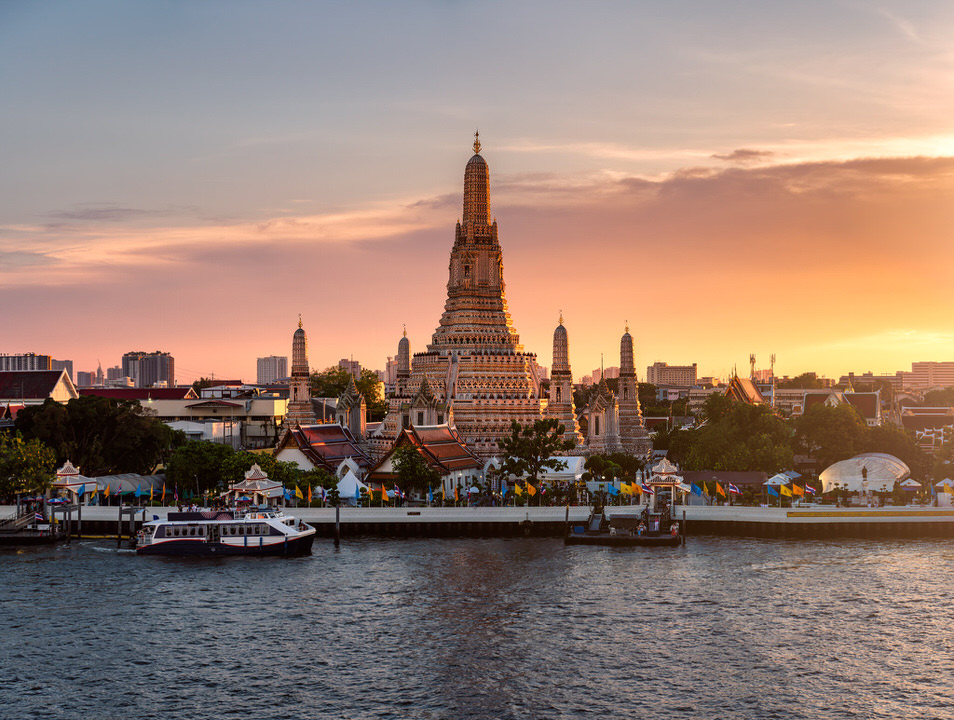 Sunset view of Wat Arun temple along the Chao Phraya River in Bangkok, Thailand