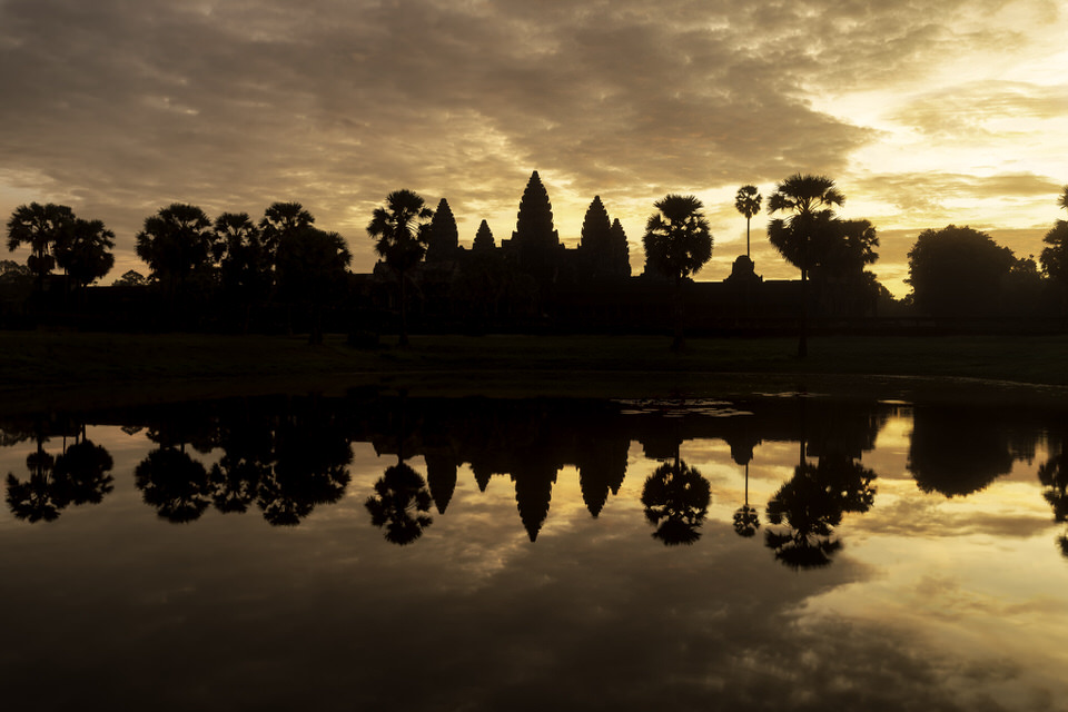 Angkor Wat temple at sunrise with its reflection in the water in Cambodia