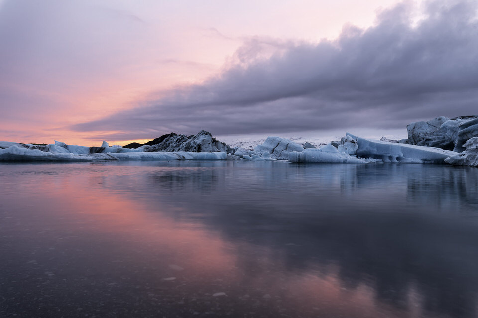 Sunset over the Glacier Lagoon in Iceland with icebergs and colorful sky reflections